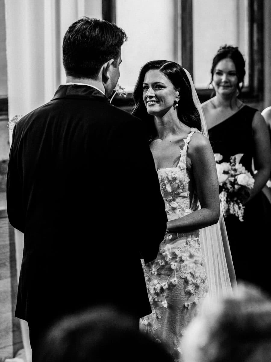 A bride smiling at her partner as they stand together during their ceremony